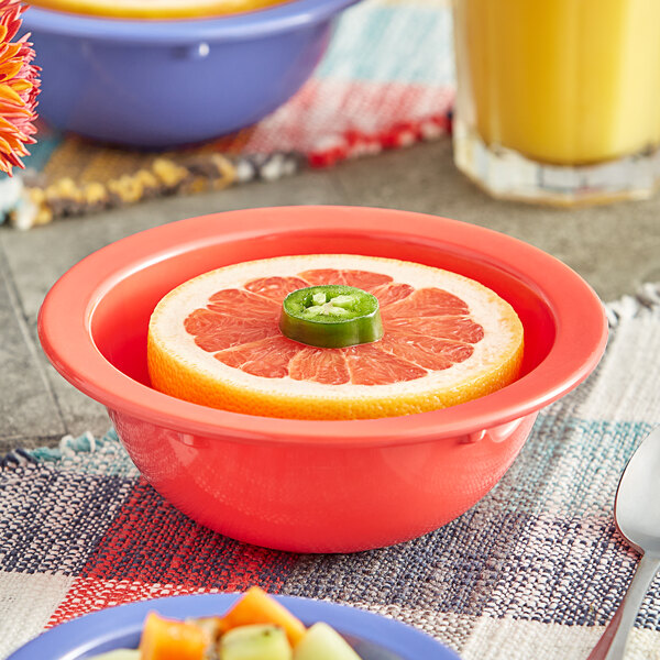 An orange grapefruit in an Acopa Foundations orange melamine bowl.