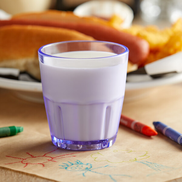 A close-up of a GET blue plastic tumbler filled with milk.