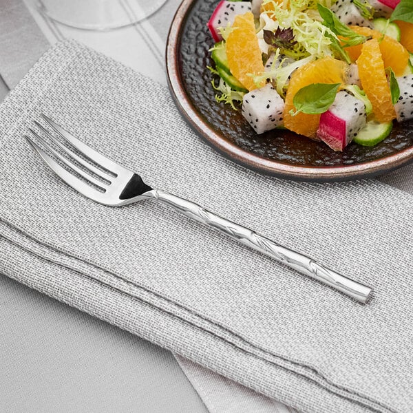 A plate of fruit salad with an Acopa Heika stainless steel fork.