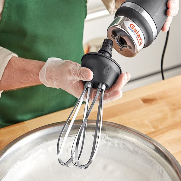 A person using a Galaxy whisk attachment to mix a bowl of batter.