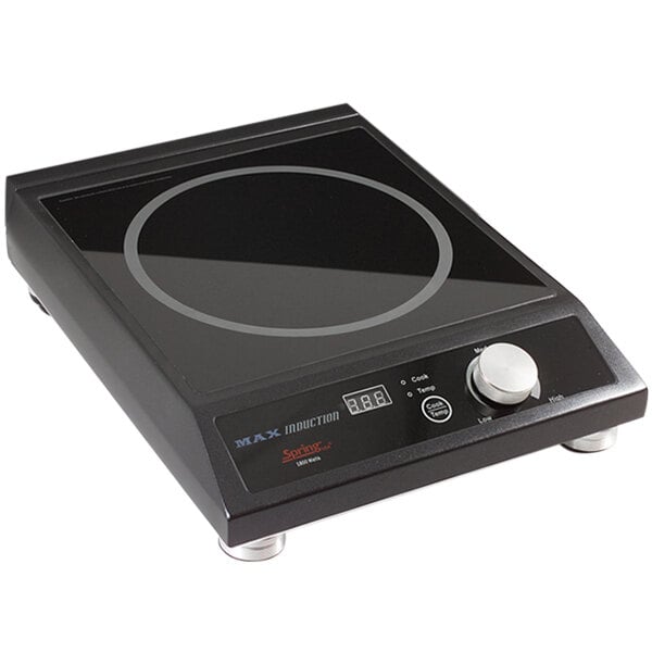 A black Spring USA MAX induction range built into a counter with a knob and glass surface.