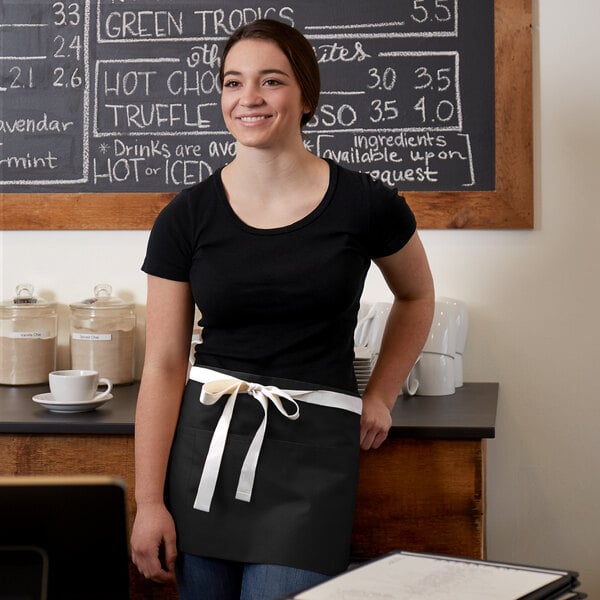 A woman wearing a black Choice waist apron with natural webbing over a black shirt.