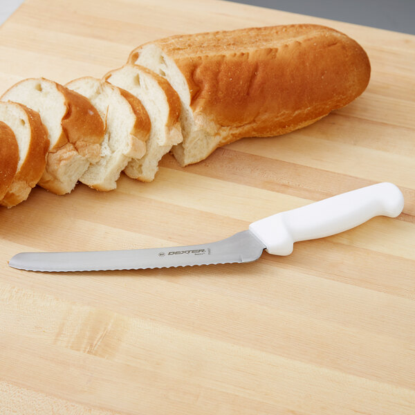 A Dexter-Russell bread knife cutting into a loaf of bread.