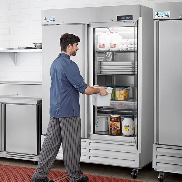 An Avantco stainless steel reach-in refrigerator with a man opening the white door.