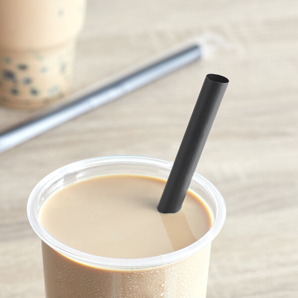 A cup of coffee with a Choice black straw in it.