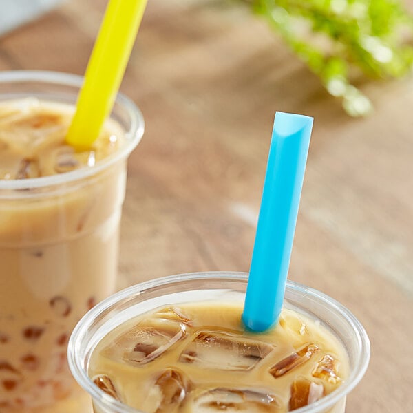 A close-up of two drinks in plastic cups with Choice neon boba straws.