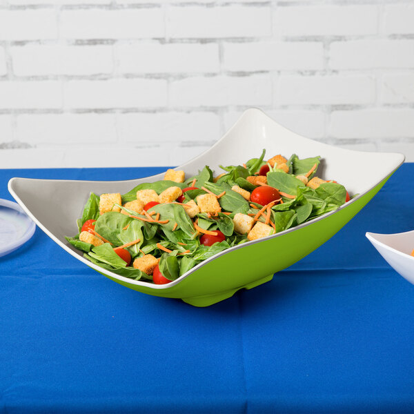 A Keywest Keylime melamine bowl filled with salad on a table.