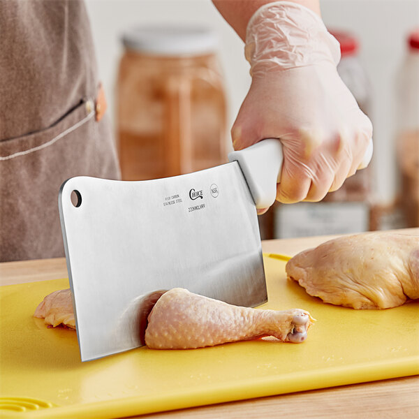 A person using a Choice 9" Cleaver to cut chicken meat.