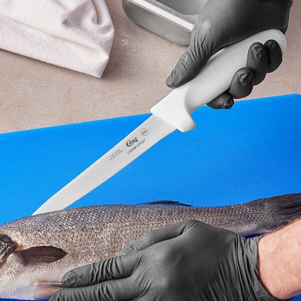 A person in gloves holding a Choice Flexible Fillet Knife over a fish.
