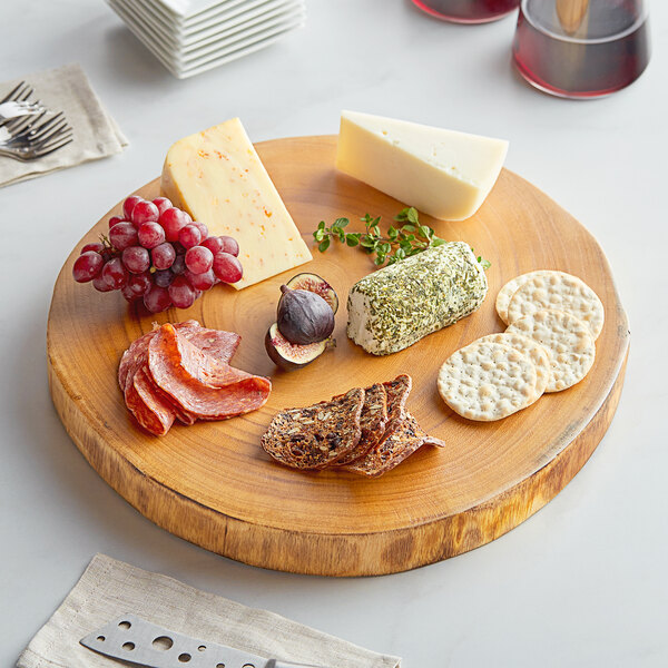 A Front of the House wooden serving board with cheese and grapes on it.