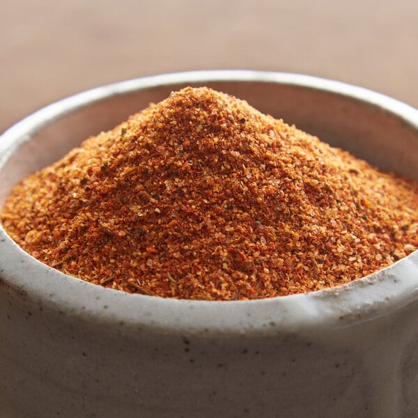 A bowl of Regal Cajun Spice seasoning with ground red spices.