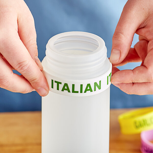 A person using a white "Italian" labeled silicone band on a plastic squeeze bottle.