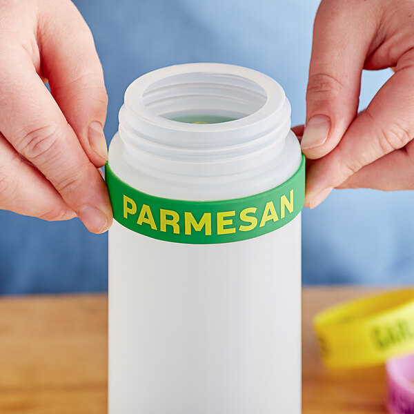 A person using Parmesan silicone label band on a squeeze bottle.