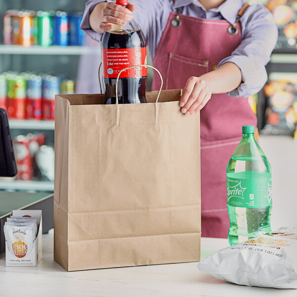 A woman putting a bottle into a Choice natural Kraft paper shopping bag.