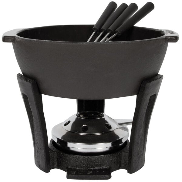 A black cast iron Boska fondue pot with utensils on a black base.