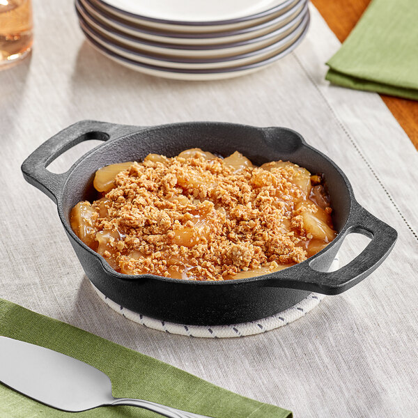 A black Valor cast iron skillet with apple crumble in it on a table.