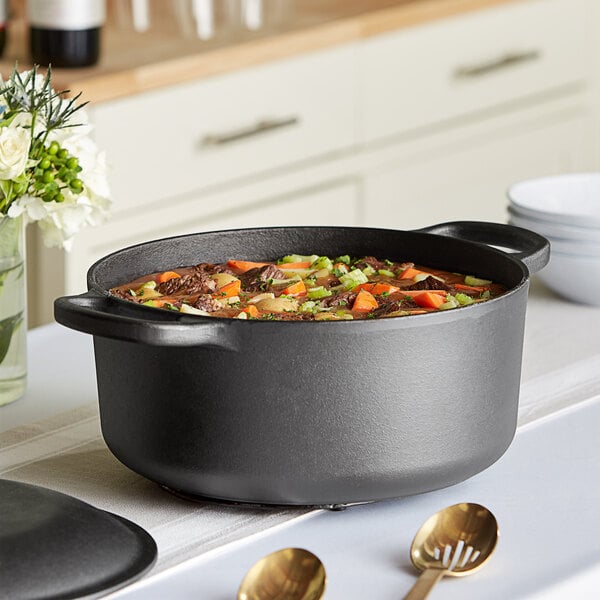 A Valor pre-seasoned cast iron Dutch oven filled with stew on a stove.