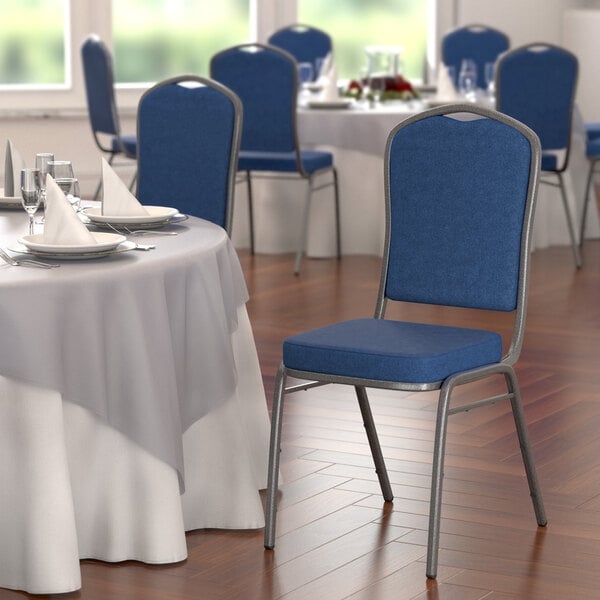 A Lancaster Table & Seating navy blue fabric banquet chair with a silver metal frame.