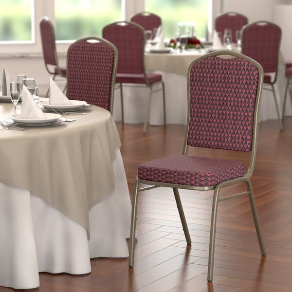 A Lancaster Table & Seating burgundy fabric banquet chair with gold vein frame.