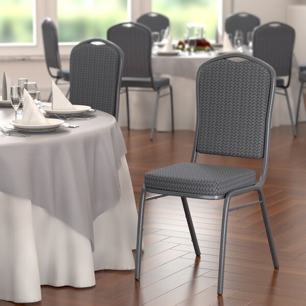 A Lancaster Table & Seating black fabric banquet chair with a patterned back and silver vein frame.