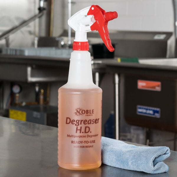 A 32 oz. labeled bottle of Noble Chemical Heavy Duty Degreaser on a counter.