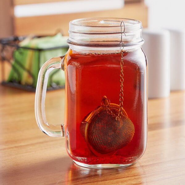 A glass jar with a Choice stainless steel tea strainer in it.