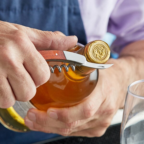 A person using an Acopa Waiter's Corkscrew to open a bottle of wine.