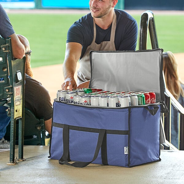 A man in an apron putting cans in a Choice navy insulated cooler bag.