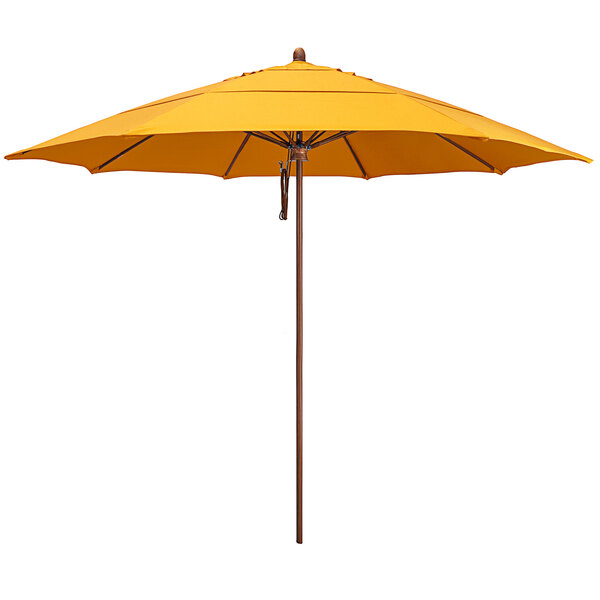 A California Umbrella round yellow Sunbrella canopy with a simulated wood pole.
