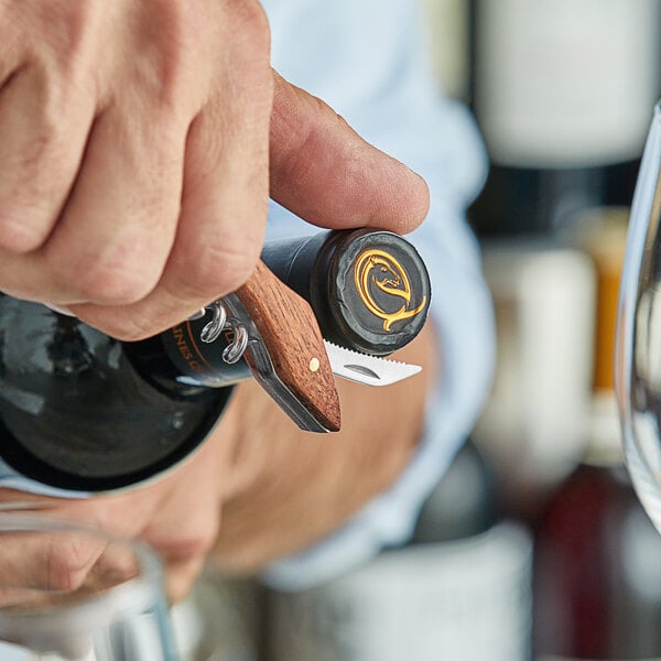 A person using an Acopa Flex Waiter's Corkscrew to open a bottle of wine.