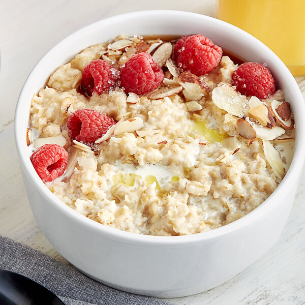 A bowl of oatmeal with raspberries and almonds.