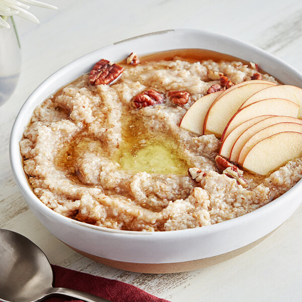 A bowl of Bob's Red Mill 7-Grain Cereal with sliced apples and pecans.