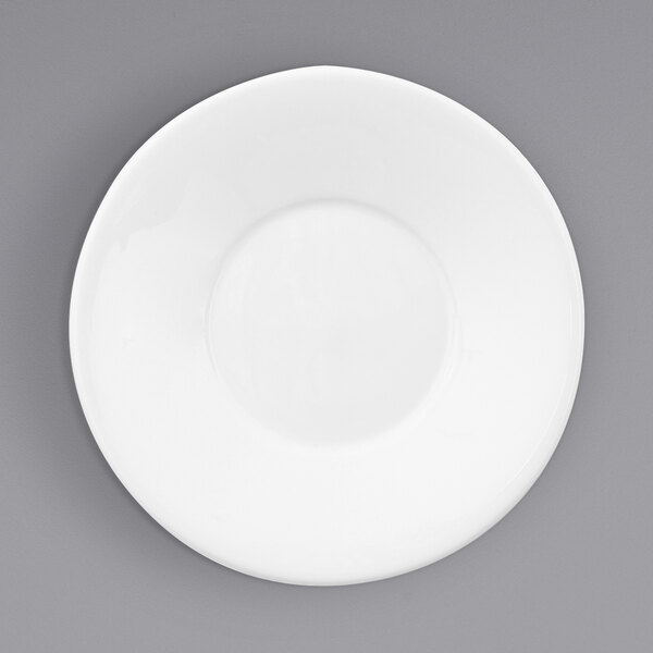 A Fortessa Ilona bright white china saucer on a gray surface.