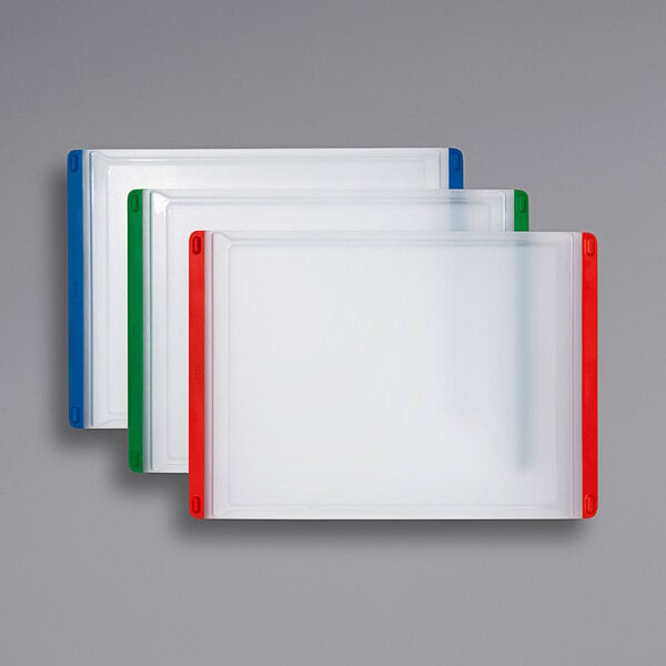 A group of white polypropylene cutting boards with red, green, and blue edges.