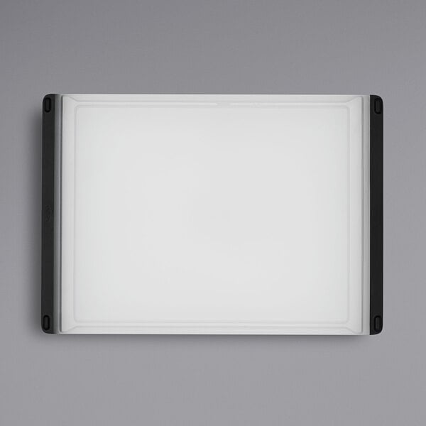 A white rectangular OXO cutting board with black corners.