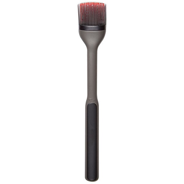 An OXO basting brush with a black handle and red bristles.