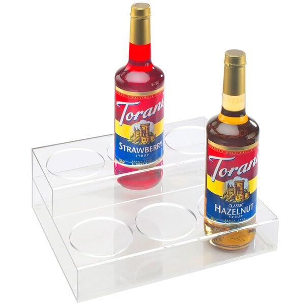 A couple of bottles of liquor on a clear acrylic 2 tier stand.