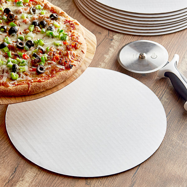 A white pizza circle on a table with a pizza.