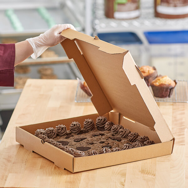 A person in gloves holding a Choice Kraft Bakery Box of cupcakes.