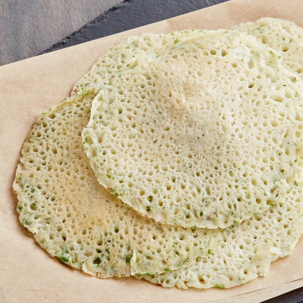A stack of rice flour pancakes on a brown paper bag.