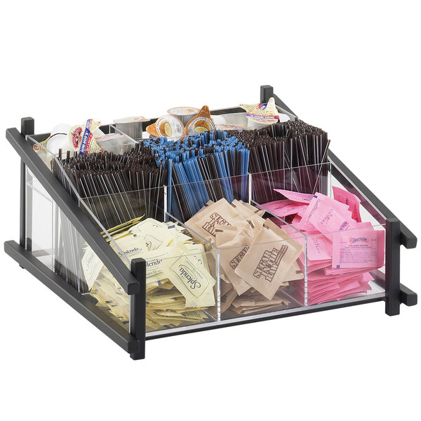 A black Cal-Mil condiment organizer on a counter with clear containers for condiments and straws.