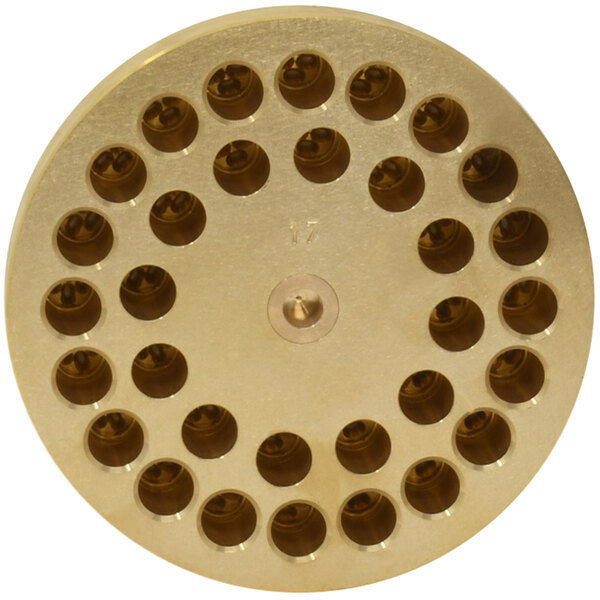 A circular brass die with holes in it.