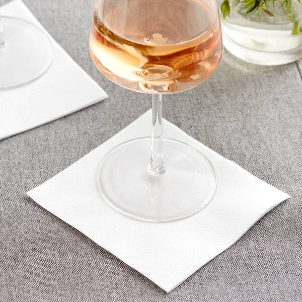 A glass of wine on a Hoffmaster Linen-Like white beverage napkin.