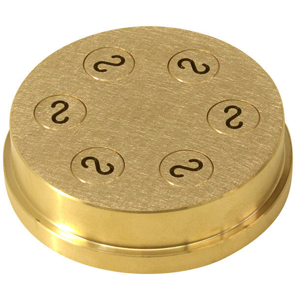 A gold circular brass die with black numbers on it.