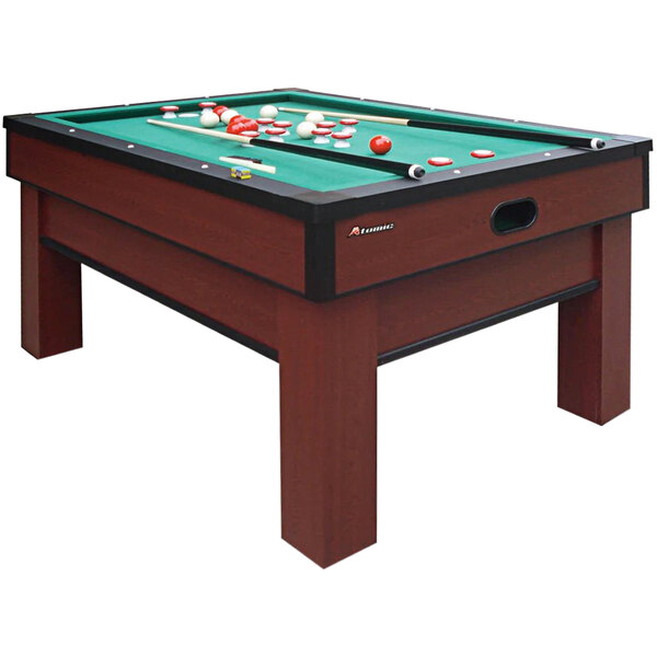 An Atomic bumper pool table with red and black cloth and balls and cues on it.