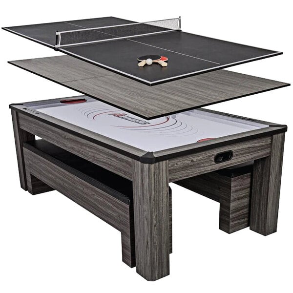 An Atomic Northport wood conversion table with ping pong paddles and a ping pong table.