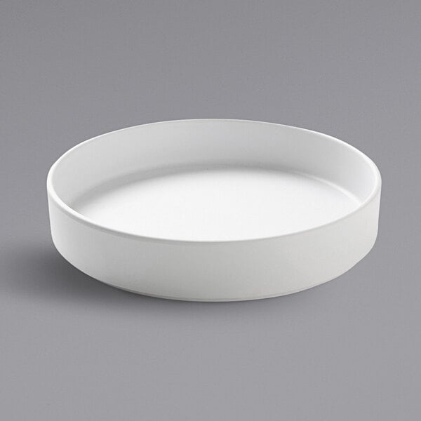 A Cal-Mil white raised rim melamine plate on a white surface.