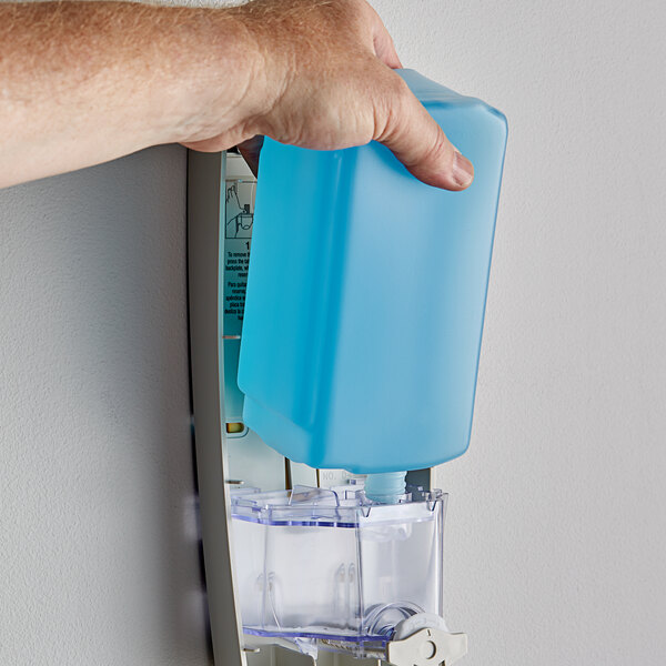 A person holding a blue Dial body wash refill bottle.