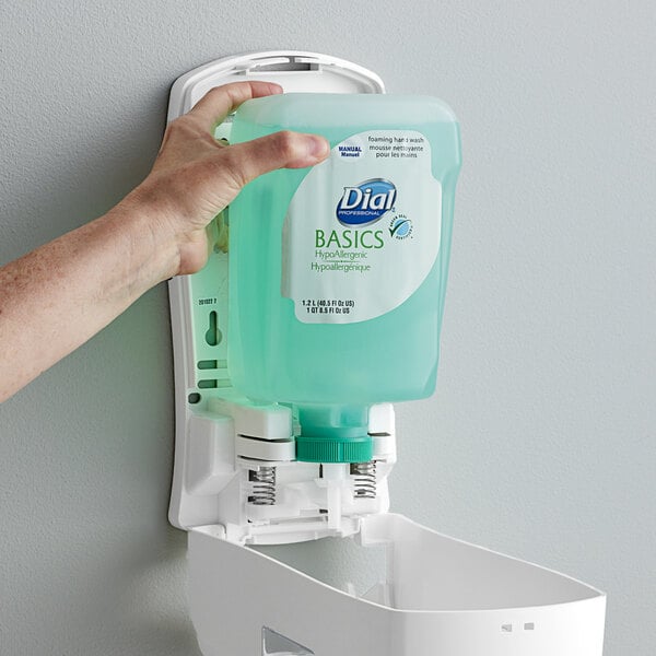 A hand holding a Dial Basics FIT liquid soap refill bottle.