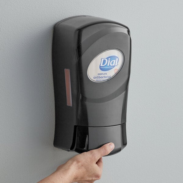 A person using a Dial FIT Universal hand soap dispenser.